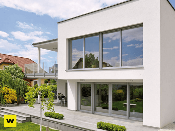 Modernes Einfamilienhaus mit großer Terrasse, bodentiefen Fenstern und Garten.